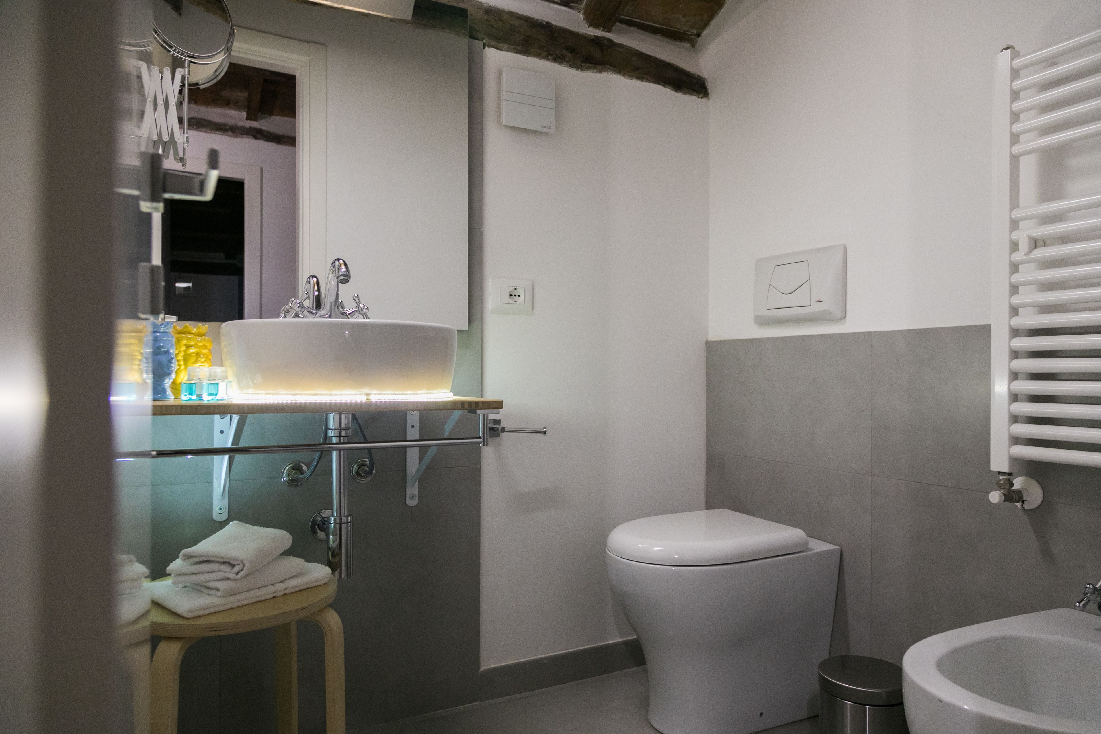 A modern bathroom with a glass shower enclosure, a toilet, and a sink with a mirror.
