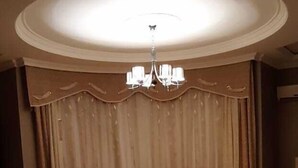 A room with a round ceiling, a chandelier, a large curtain, and a seating area with a coffee table. - Bakuvi Tourist Apartment B022 (Baku)