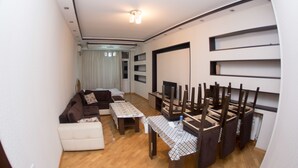 Una sala de estar moderna con un sofá, una mesa de centro y un comedor con sillas y una mesa.