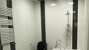 A modern bathroom with a black and white tiled design, a freestanding bathtub, a toilet, and a shower area. - Bakuvi Tourist Apartment B096 (Baku)