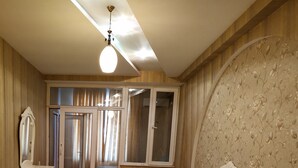 A bedroom with a bed, nightstands, a dresser, a mirror, and a wardrobe. - Bakuvi Tourist Apartment B096 (Baku)