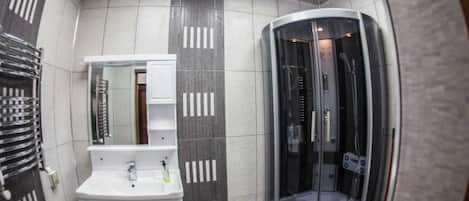 Căn hộ | Phòng tắm | Buồng tắm vòi sen, máy sấy tóc, dép đi trong nhà, xà phòng