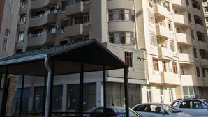 A high-rise residential building with multiple balconies and a covered outdoor seating area. - Bakuvi Tourist Apartment B097 (Baku)