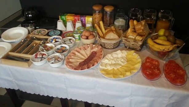 A buffet table with various food items including meats, cheeses, fruits, and condiments.