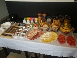A buffet table with various food items including meats, cheeses, fruits, and condiments. - TSC Pansion (Sarajevo)