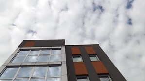 A modern building with a glass facade and brown accents.