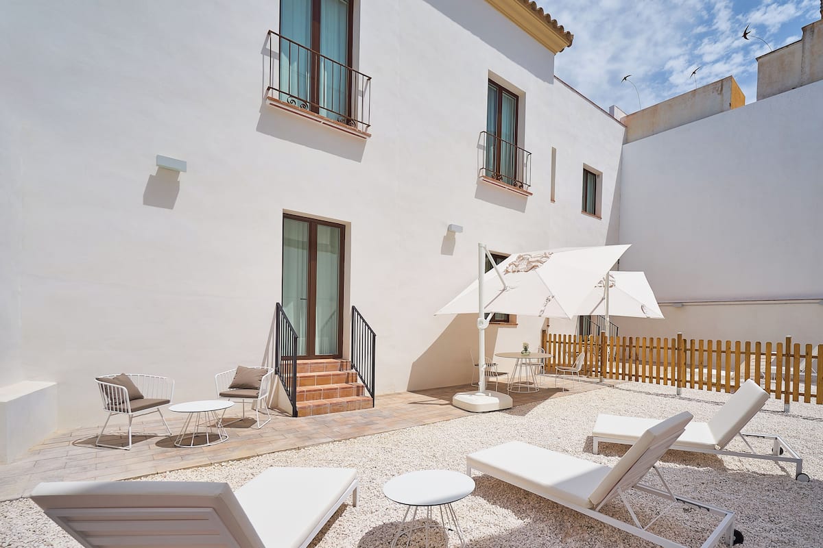 A courtyard with outdoor seating, a staircase, and a wooden fence.