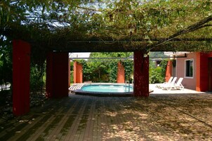 Una piscina al aire libre de temporada, tumbonas