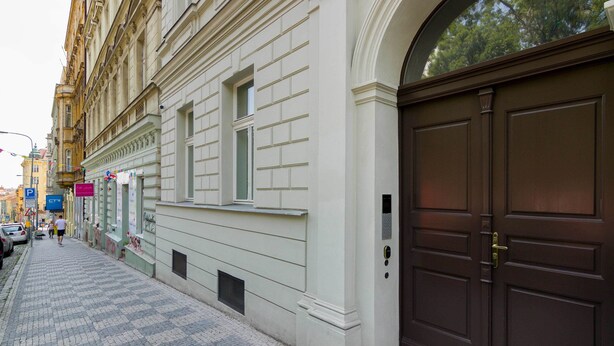 Un bâtiment doté d’une grande porte en bois sombre et d’un trottoir pavé.