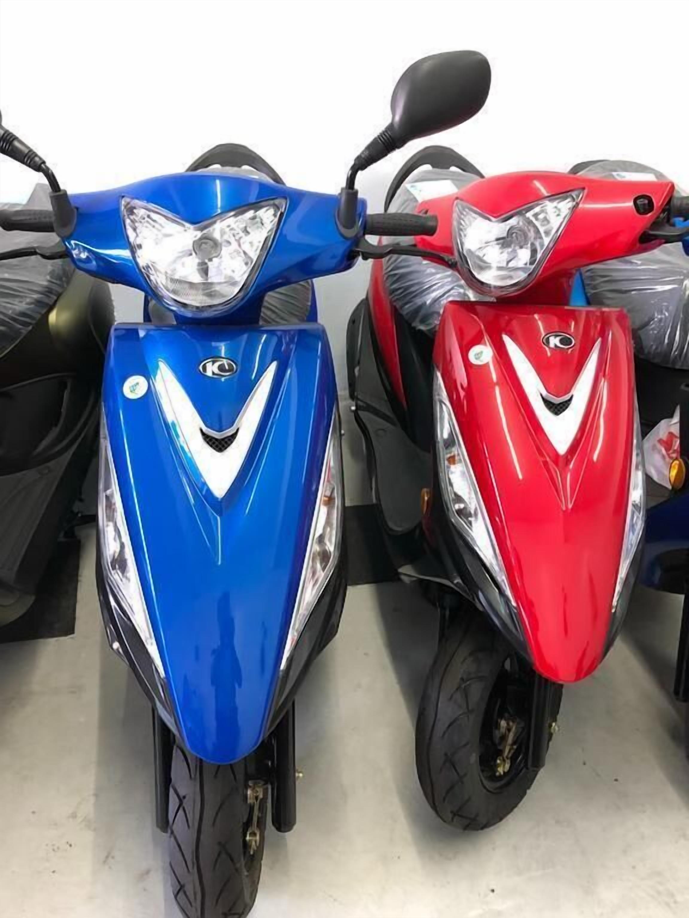 Two scooters, one blue and one red, parked side by side.