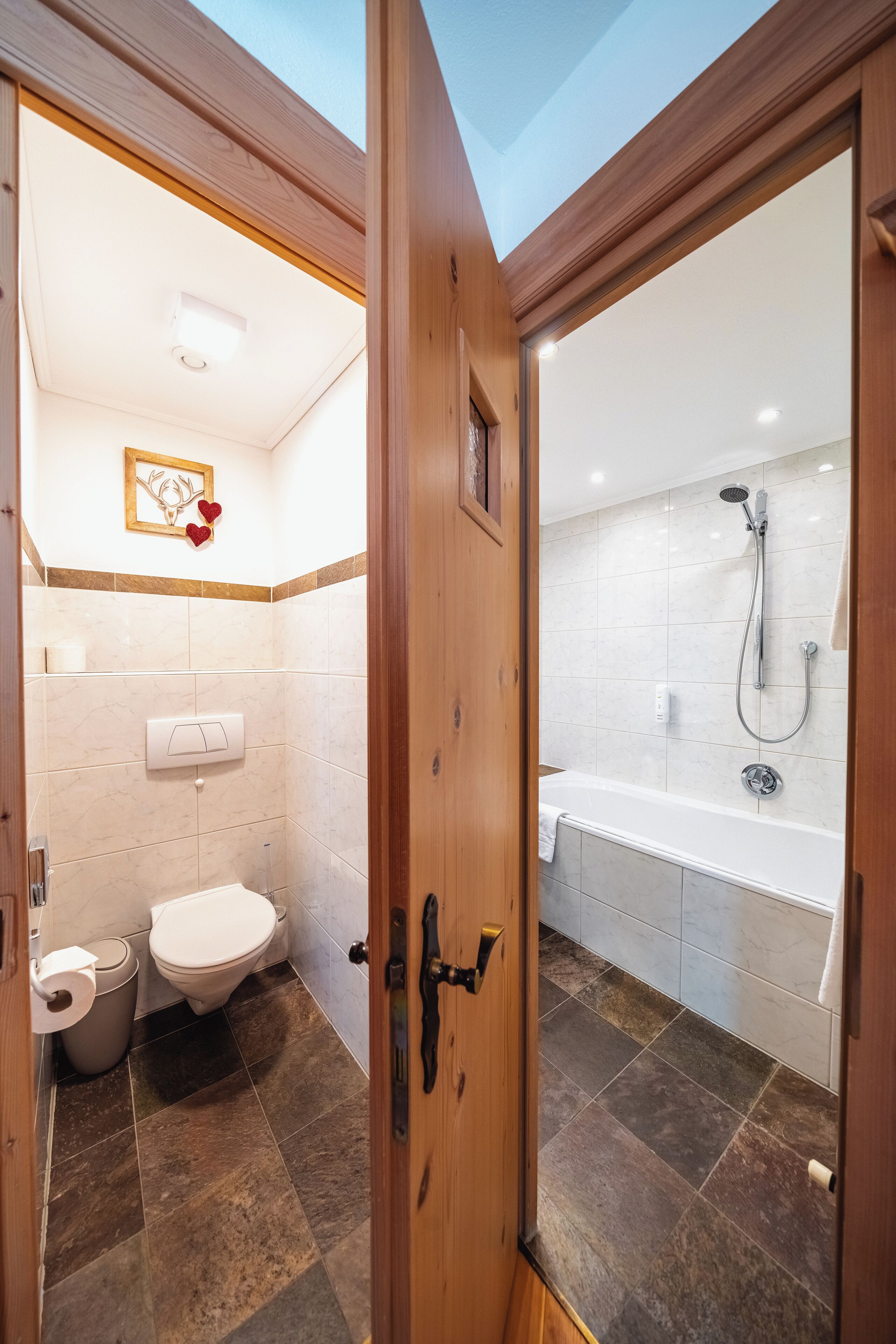 A bathroom with a toilet, sink, and shower area.