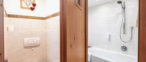 A bathroom with a toilet, sink, and shower area.