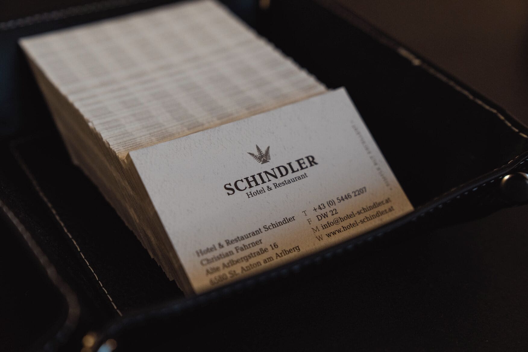Tarjeta de presentación del Hotel & Restaurant Schindler, con datos de contacto y dirección.