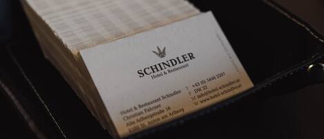 Tarjeta de presentación del Hotel & Restaurant Schindler, con datos de contacto y dirección.
