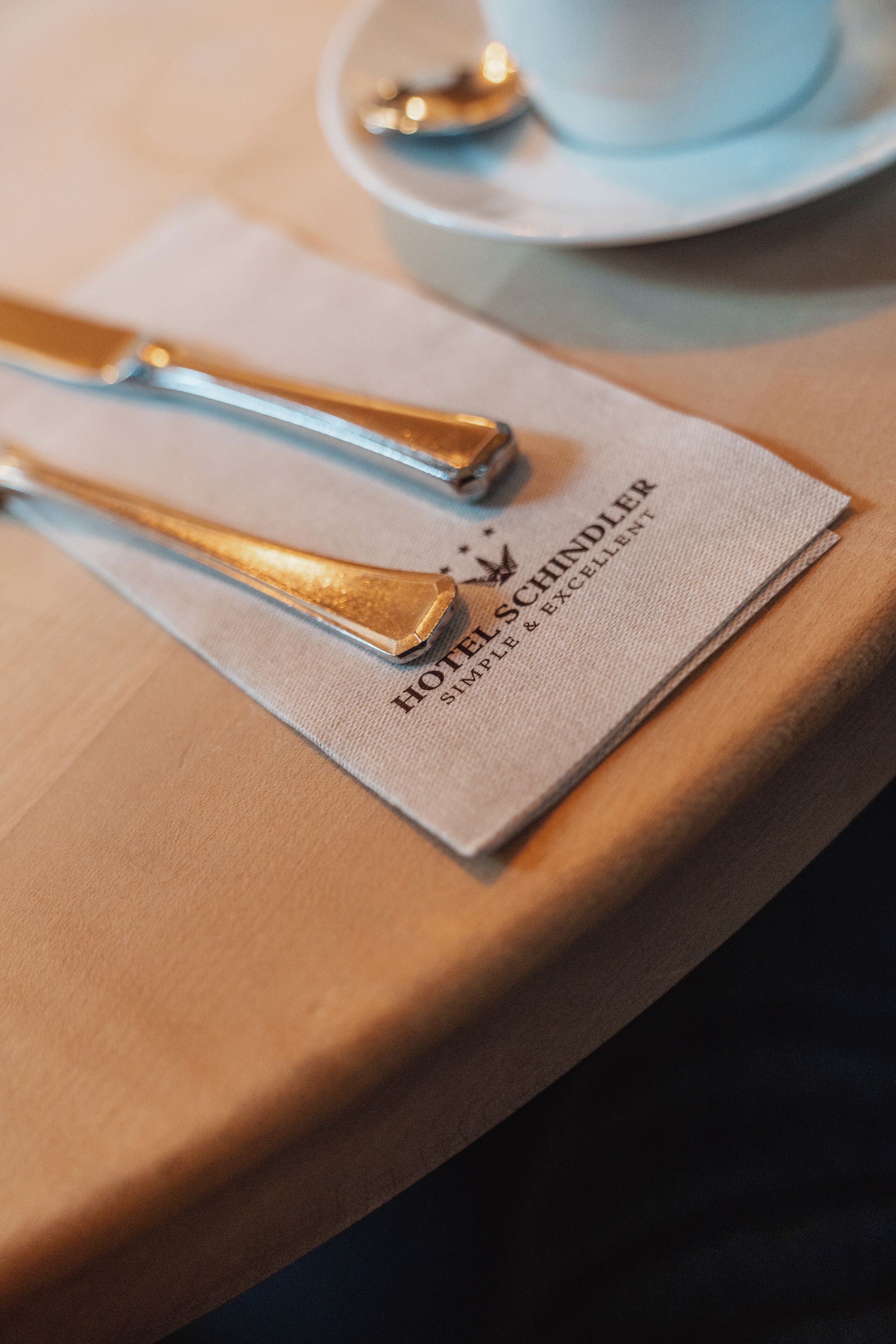 A table setting with a napkin, a spoon, and a knife on a table.
