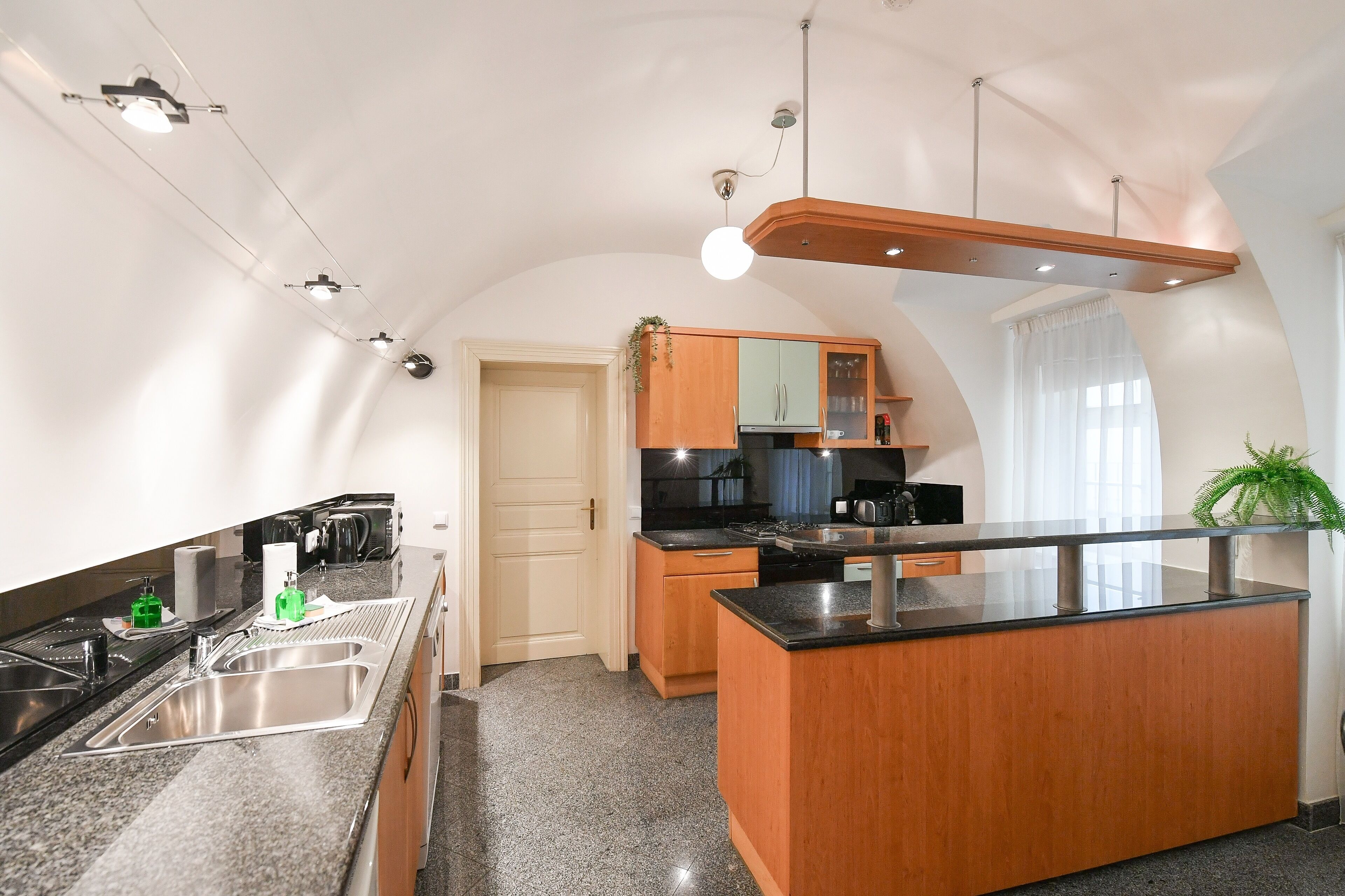 A modern kitchen with granite countertops, stainless steel appliances, and wooden cabinetry.