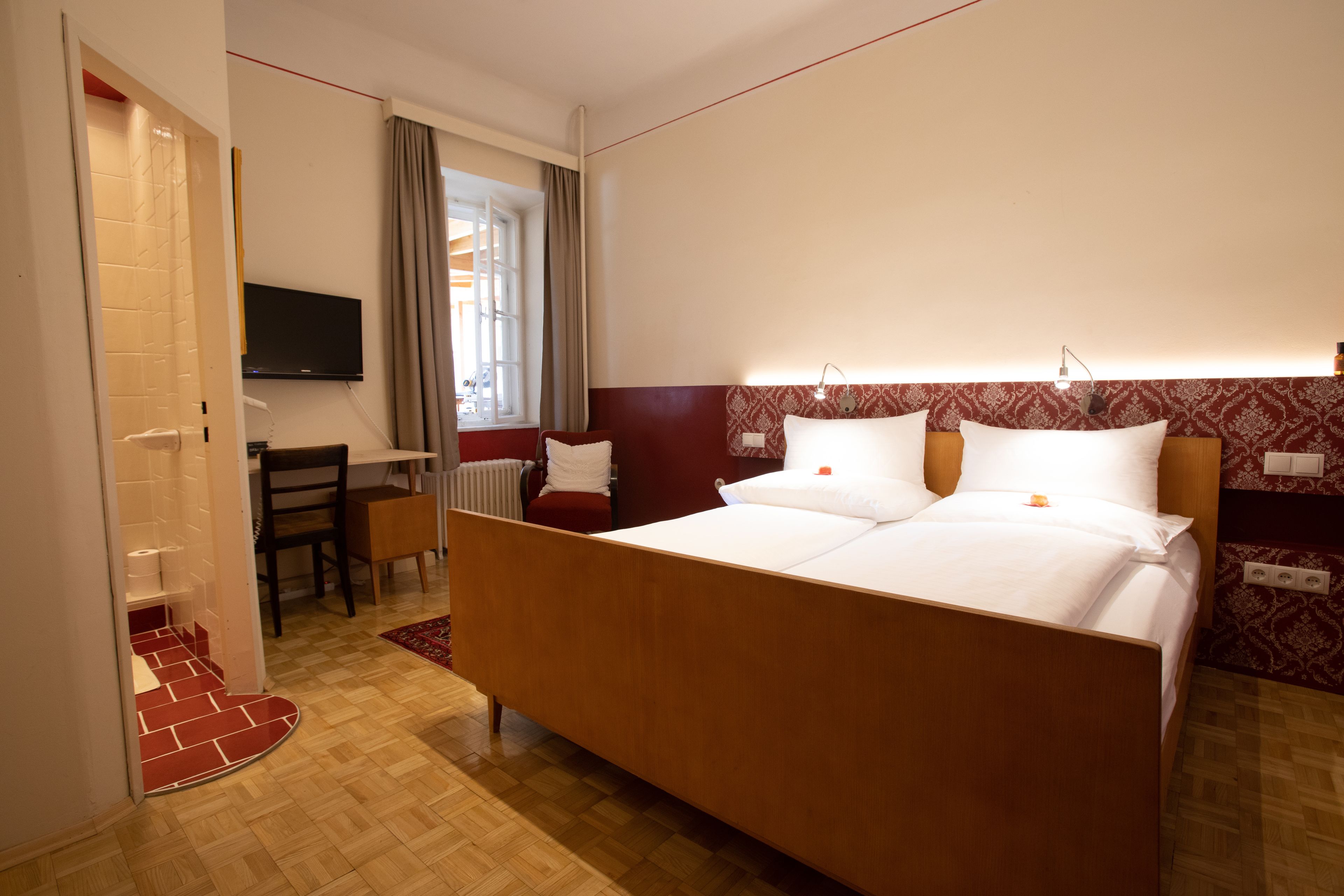 Une chambre d’hôtel avec un grand lit, un bureau et une télévision.