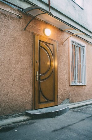 A building with a textured wall and a circular door with a handle. - Studio in the city center (Odesa)