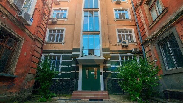 A multi-story building with a central entrance, large windows, and air conditioning units. - Apartment City Center Osipova 4 (Odesa)