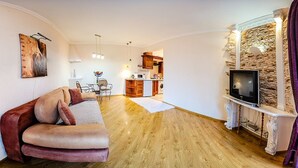 A living room with a sofa, a television, and a kitchen in the background. - Balcony Apartment near Deribasovskaya (Odesa)