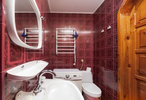 A bathroom with a white sink, a toilet, and a mirror. - Apartment near Opera Theater (Lviv)