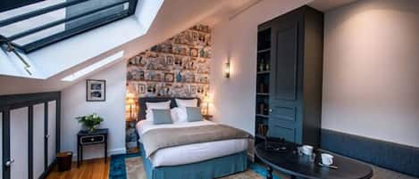 Ein gemütliches Schlafzimmer mit Oberlichter, einem Bett, einem kleinen Tisch und einer Sitzecke.