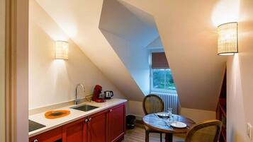 A compact kitchen with a red countertop, a sink, and a window providing natural light.