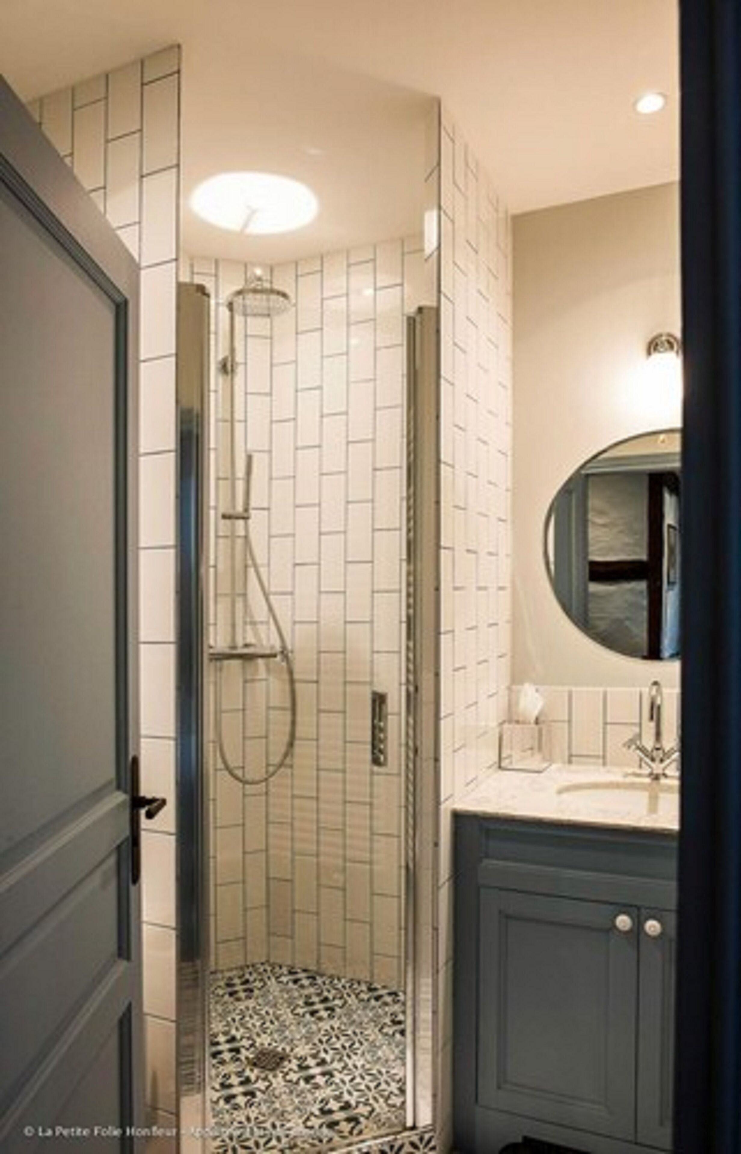 A bathroom with a shower, a sink, and a mirror.