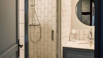 A bathroom with a shower, a sink, and a mirror.
