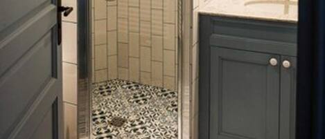Ein Badezimmer mit Dusche, Waschbecken und Spiegel.