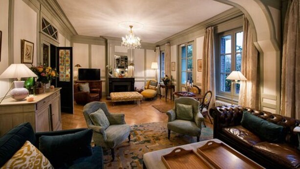 A spacious living room with a fireplace, comfortable seating, and a chandelier. - La Petite Folie (Honfleur)