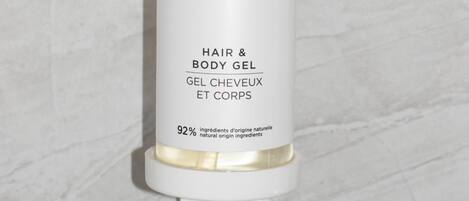Un flacon de gel pour le corps BIENVENUE doté d’un distributeur à pompe, dont l’étiquette indique qu’il contient 92 % d’ingrédients d’origine naturelle.