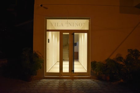 The entrance to Vila Nino with a glass door and a sign above it.