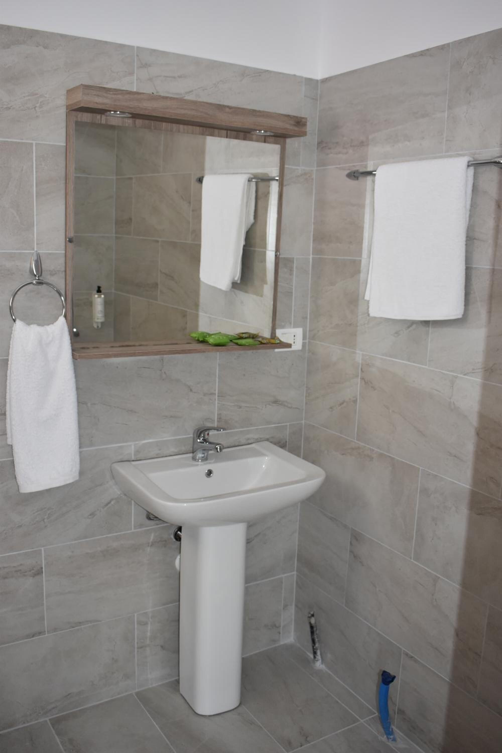 A bathroom with a sink, mirror, and towel rack.
