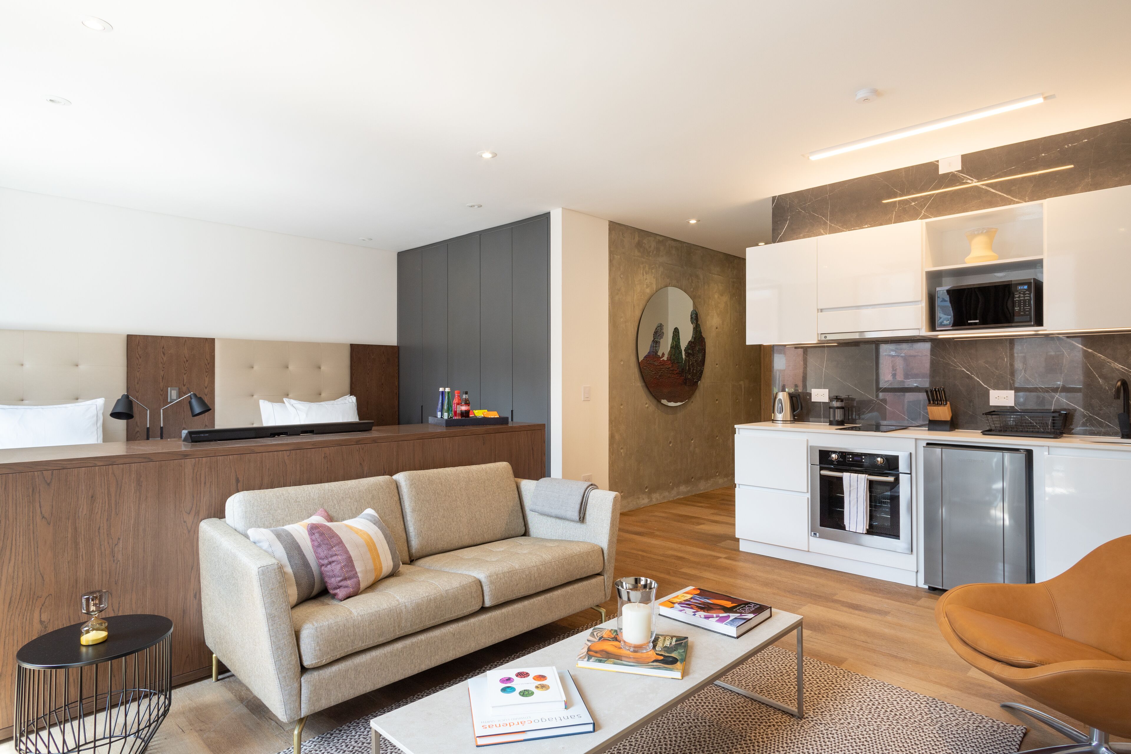 Une chambre d’hôtel moderne équipée d’un canapé, d’une table basse et d’une kitchenette.