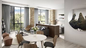 Un salon moderne avec une table à manger ronde, des sièges confortables, un canapé et une grande fenêtre donnant sur la ville.