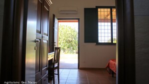 An interior view of a room with a wooden door, a window with a grid pattern, and a chair.