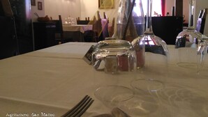 A dining table with various glassware and a decorative centerpiece.