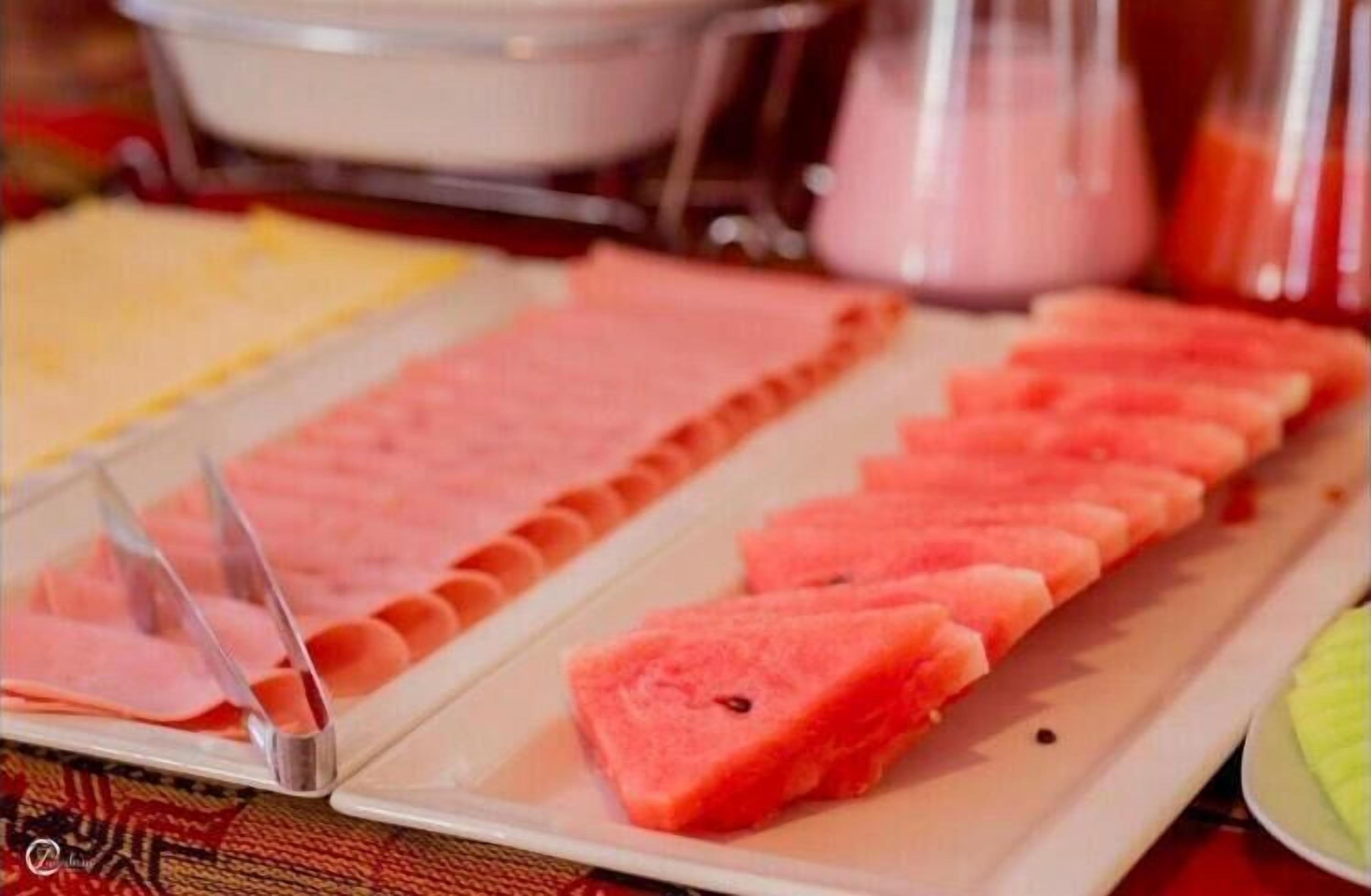 A buffet with various food items including watermelon slices and other dishes.