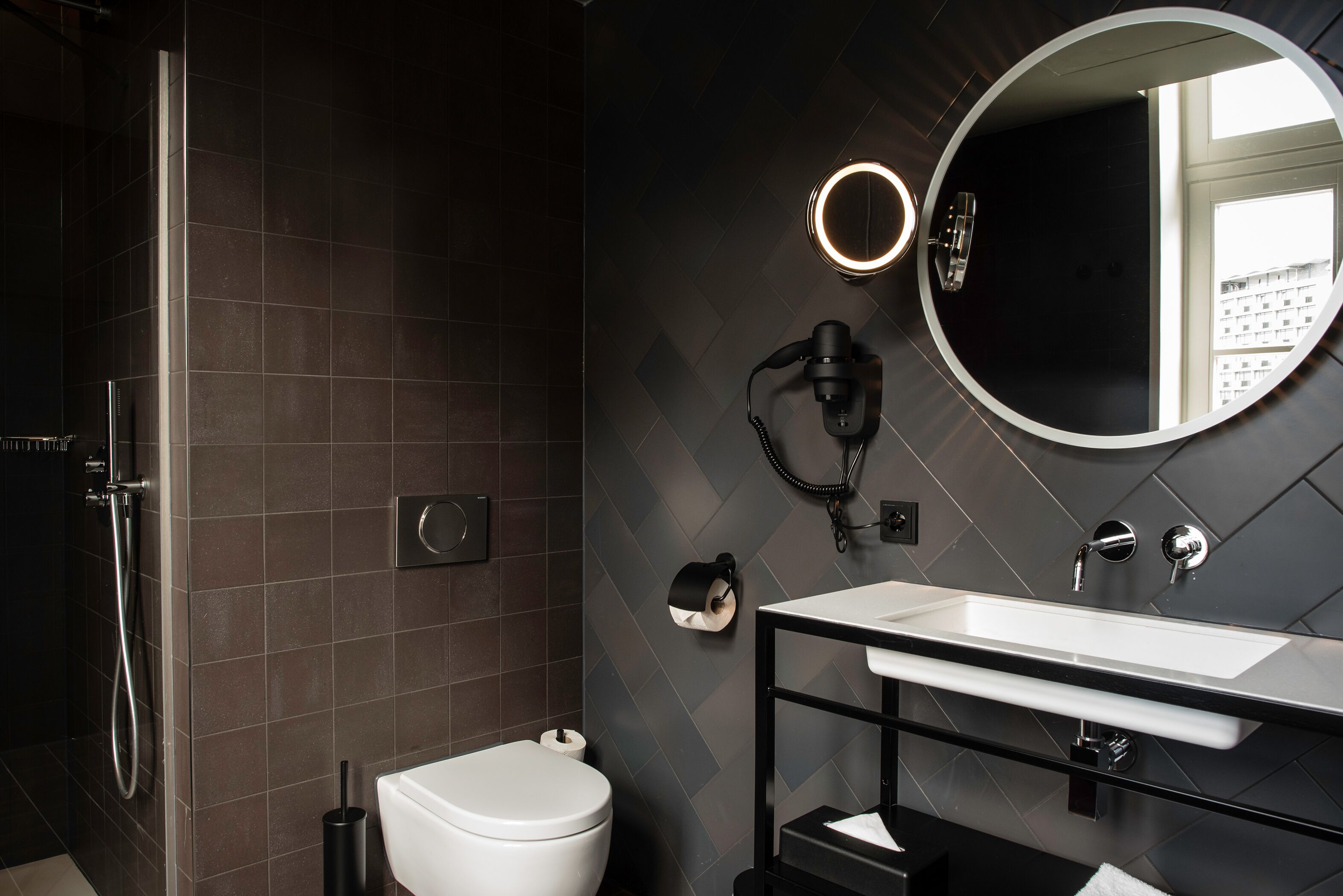Un baño moderno con ducha, inodoro y tocador con espejo y lavabo.