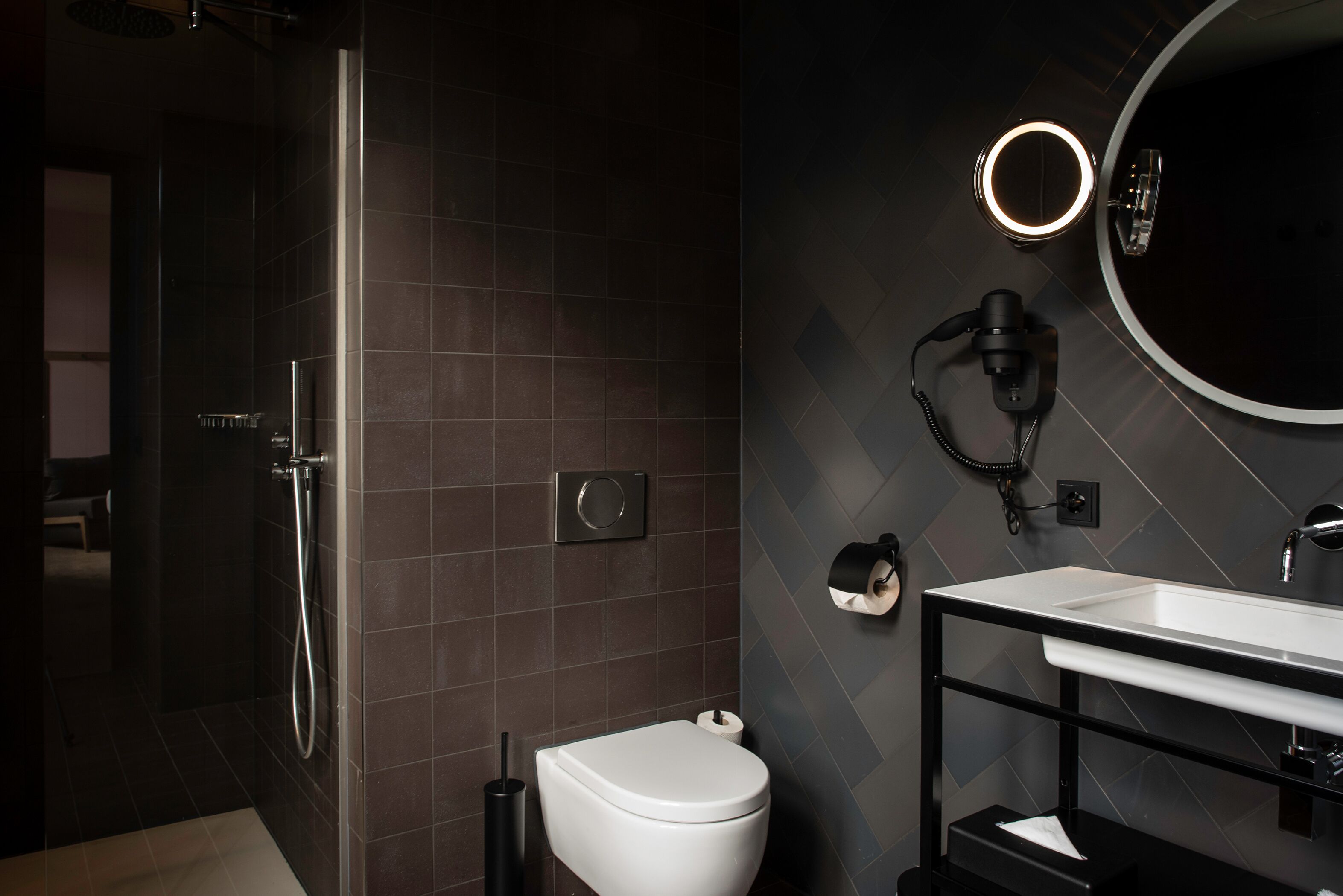 A modern bathroom with a shower, toilet, and sink.