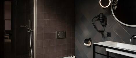 A modern bathroom with a shower, toilet, and sink.