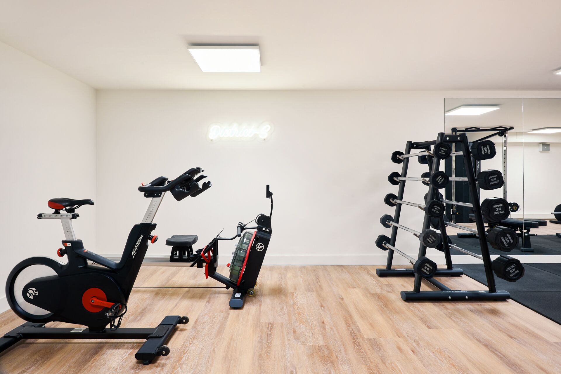 A gym with exercise bikes, a treadmill, and a weight rack.
