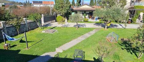 A backyard with a dining area, a hammock, and a small garden.