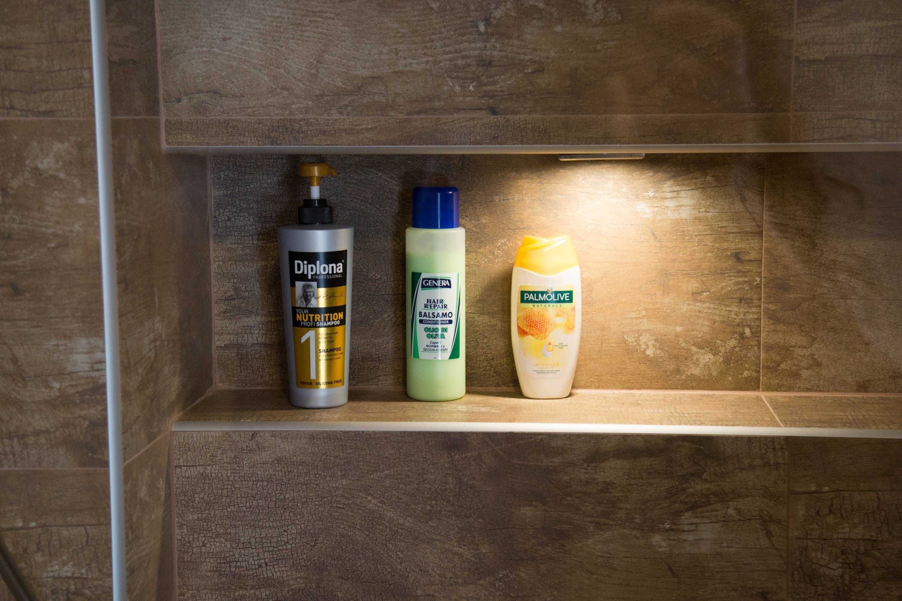 Une étagère avec trois bouteilles de produits pour les soins capillaires.