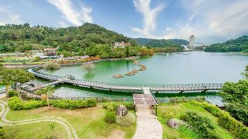 A riverside park with a bridge, walking paths, and a pavilion.