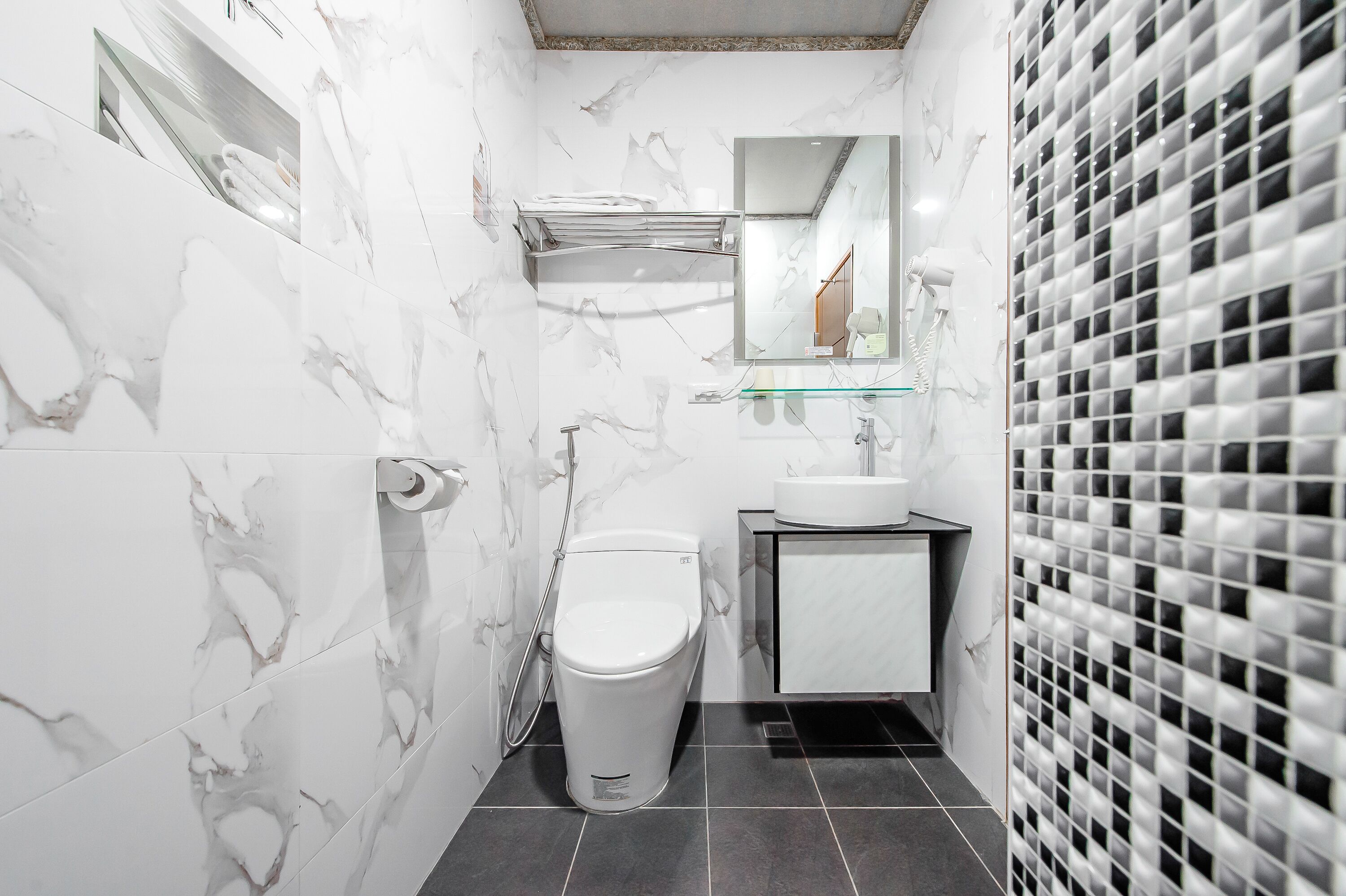 A modern bathroom with a toilet, sink, and mirror.