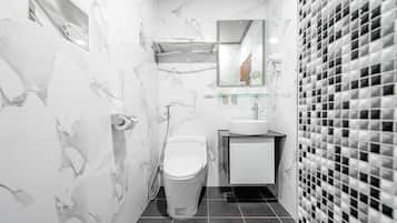 A modern bathroom with a toilet, sink, and mirror.