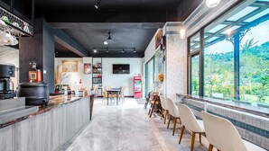 A modern kitchen with a central island, a dining area with chairs, and a large window offering a view of greenery. - I Love You Homestay (Yuchi)