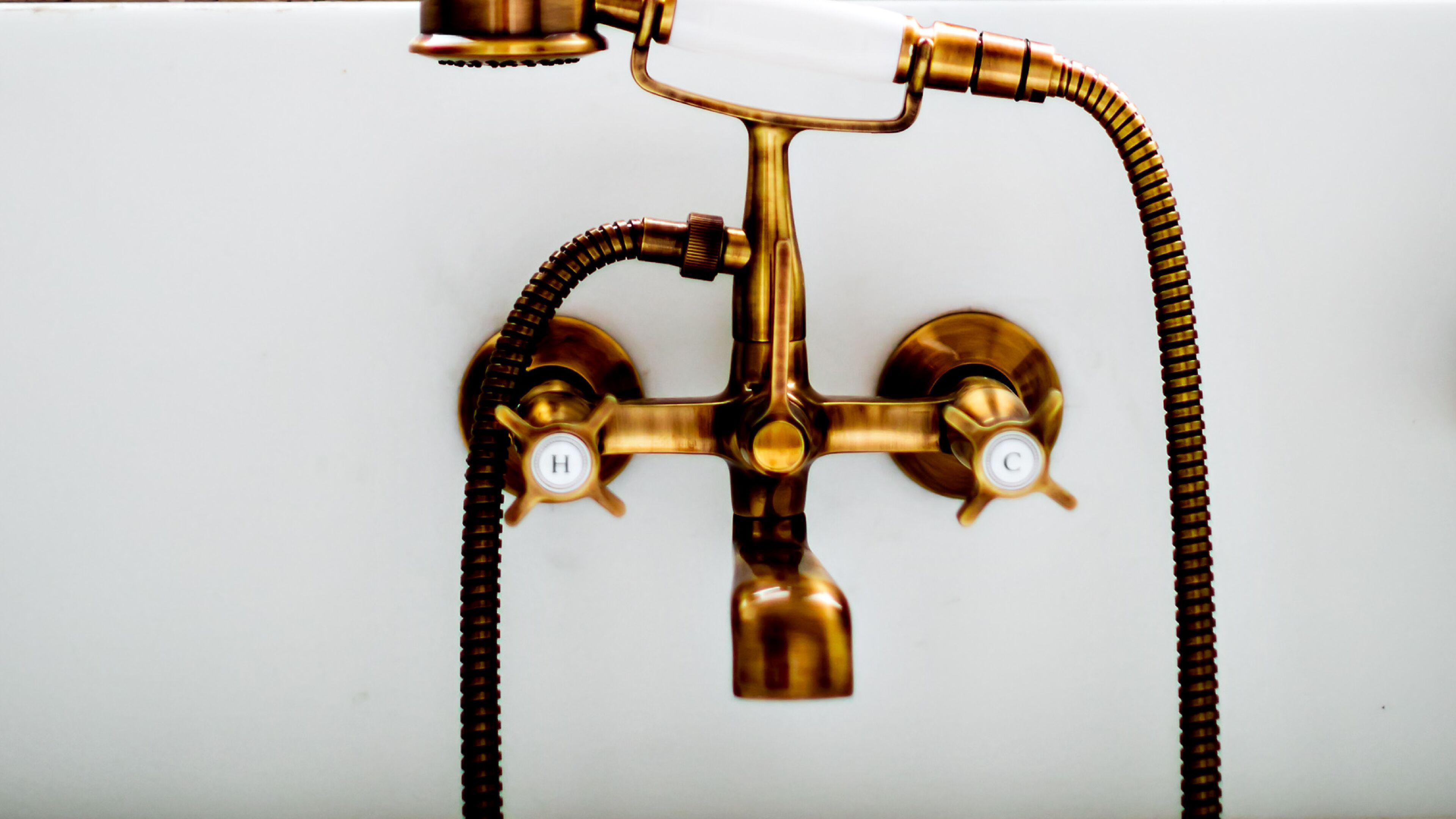 Un accesorio de baño de bronce con una sola palanca y una manguera flexible.